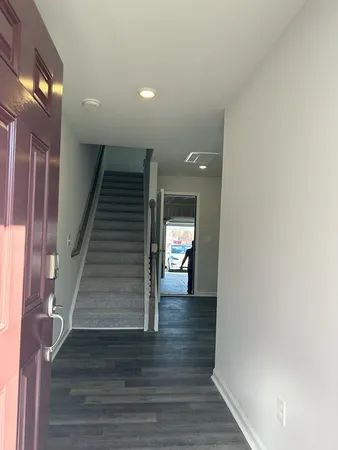 a view of a hallway with wooden floor and staircase