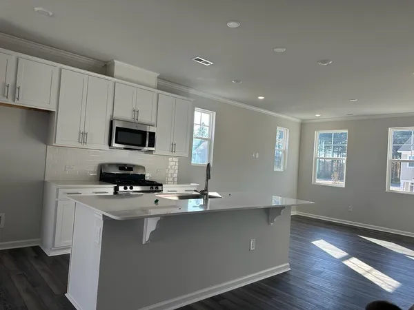 a kitchen with granite countertop a sink a counter space appliances and cabinets