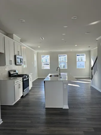 a kitchen with a sink cabinets and wooden floor