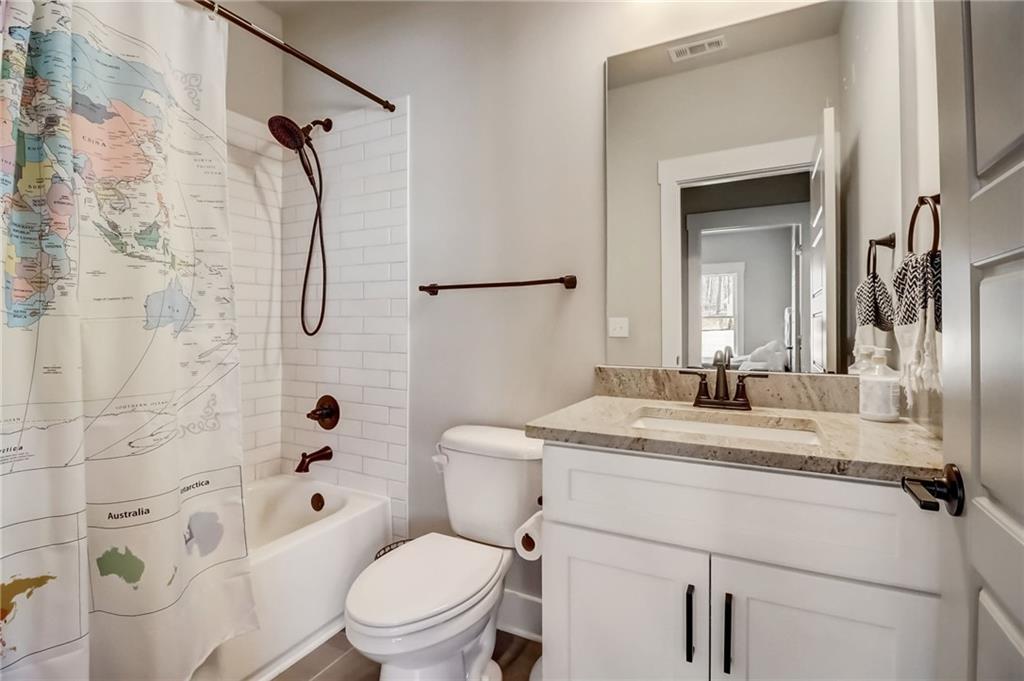 569 White Oak Way Monroe, GA 30655 - Photo 17 of 50 a bathroom with a granite countertop sink toilet a mirror a vanity and shower