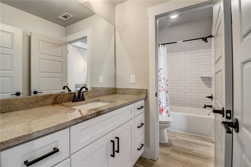 569 White Oak Way Monroe, GA 30655 - Photo 34 of 50 a bathroom with a granite countertop sink and a mirror a bathtub