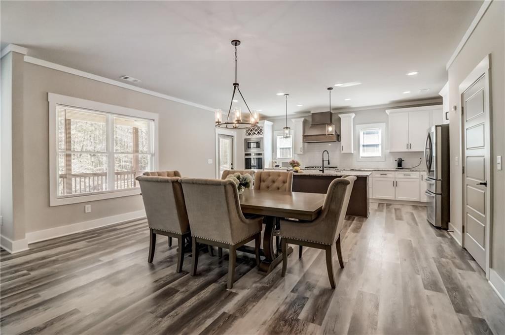 569 White Oak Way Monroe, GA 30655 - Photo 10 of 50 a view of a dining room with furniture window and wooden floor