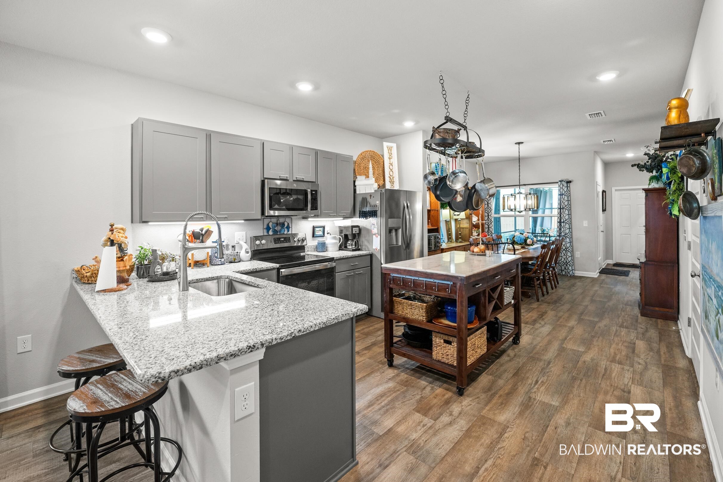 24139 Veranda Circle Elberta, AL 36530 - Photo 7 of 40 Kitchen featuring gray cabinets, stainless steel appliances, a breakfast bar area, and a sink
