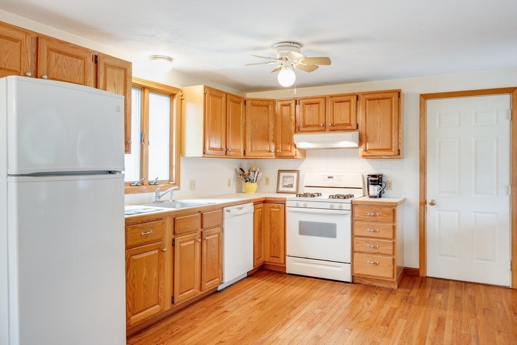 221 Camelback Road Barnstable, MA 02648 - Photo 14 of 31 a kitchen with a white cabinets and wooden floor