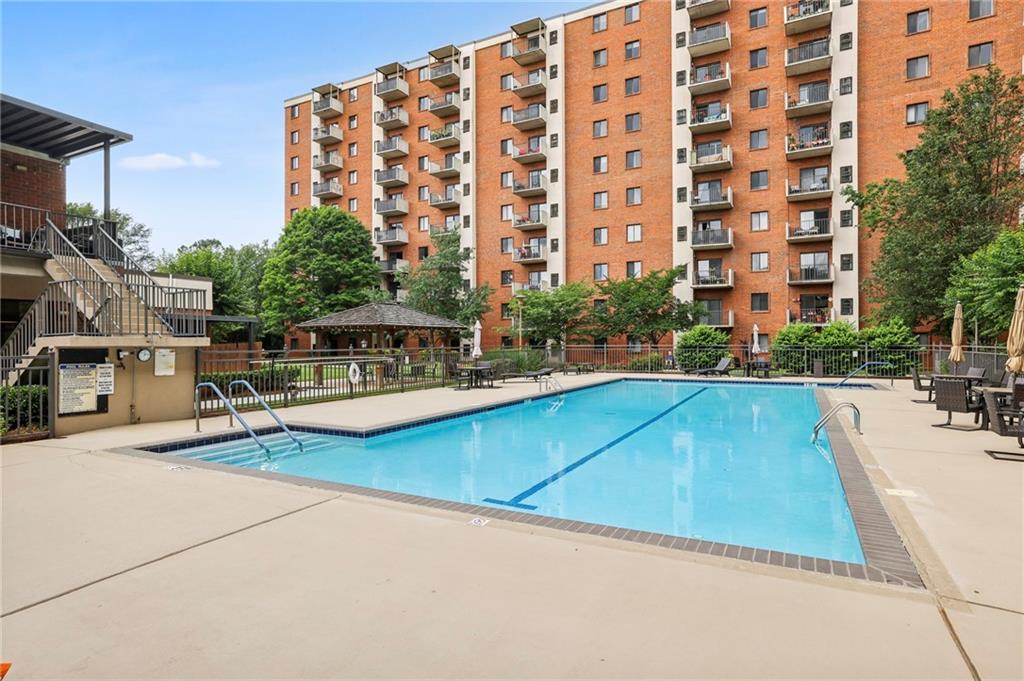 300 Johnson Ferry Road, Unit B804 Sandy Springs, GA 30328 - Photo 28 of 37 a view of swimming pool with outdoor seating and buildings in the background