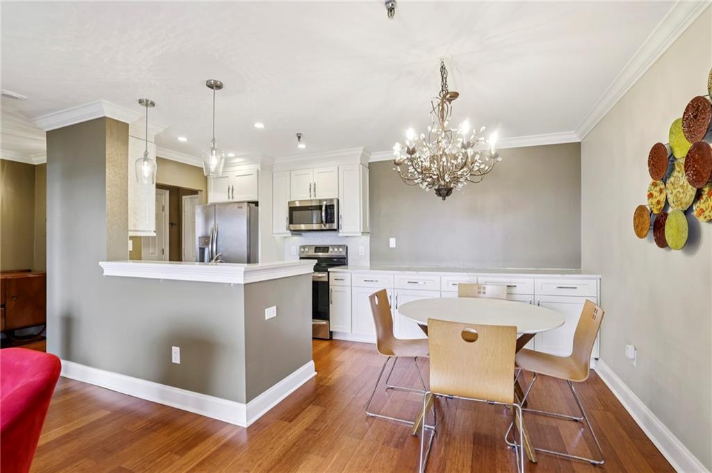 300 Johnson Ferry Road, Unit B804 Sandy Springs, GA 30328 - Photo 3 of 37 a kitchen with stainless steel appliances kitchen island granite countertop a dining table chairs and a refrigerator