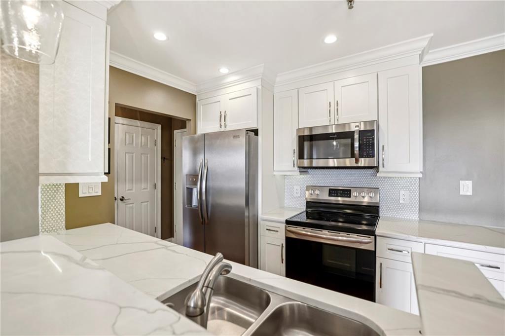300 Johnson Ferry Road, Unit B804 Sandy Springs, GA 30328 - Photo 8 of 37 a kitchen with stainless steel appliances kitchen island granite countertop a refrigerator and a stove top oven