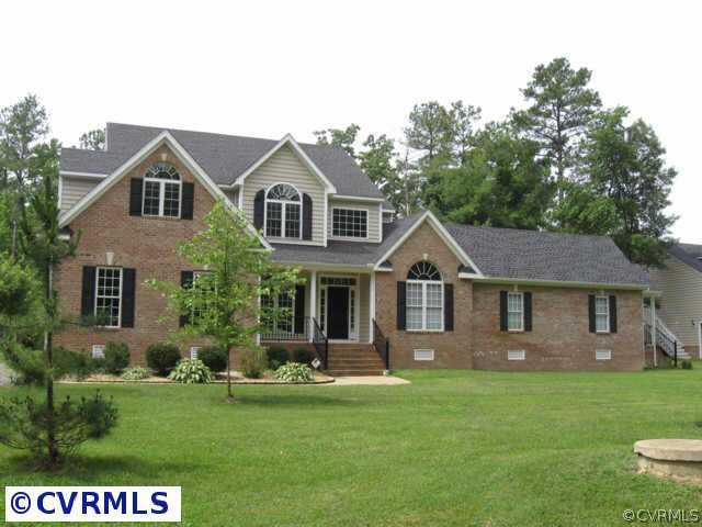 a front view of a house with a yard and green space