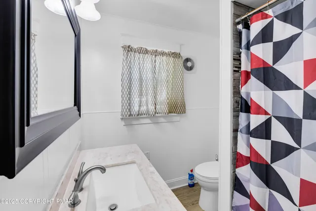 a view of a hallway with wooden floor and white walls