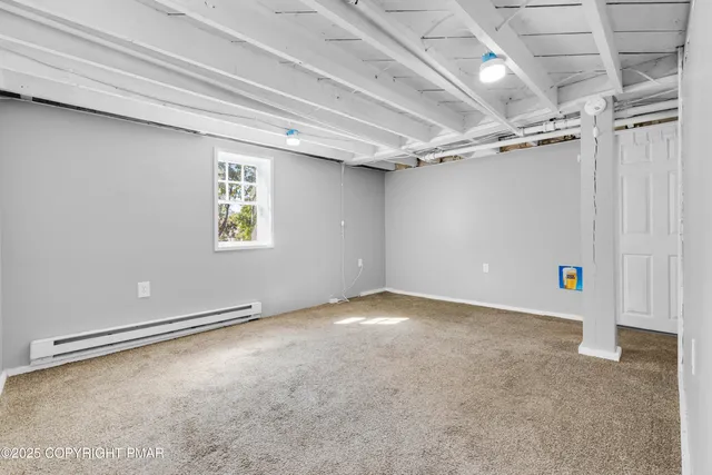 a view of a house with a large window and flower plants