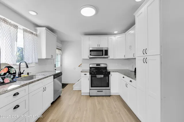 a kitchen with stainless steel appliances a refrigerator sink and cabinets