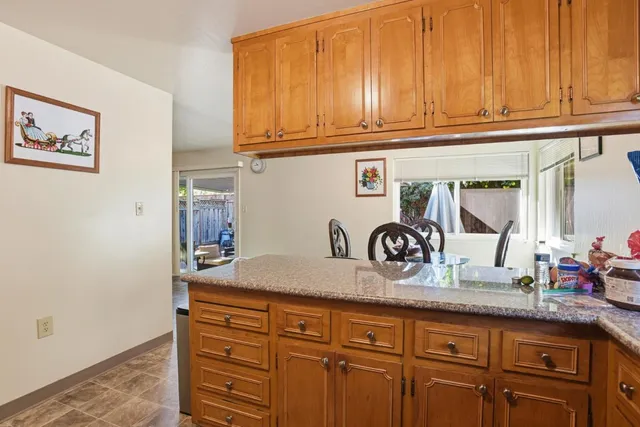 a kitchen with granite countertop cabinets and window