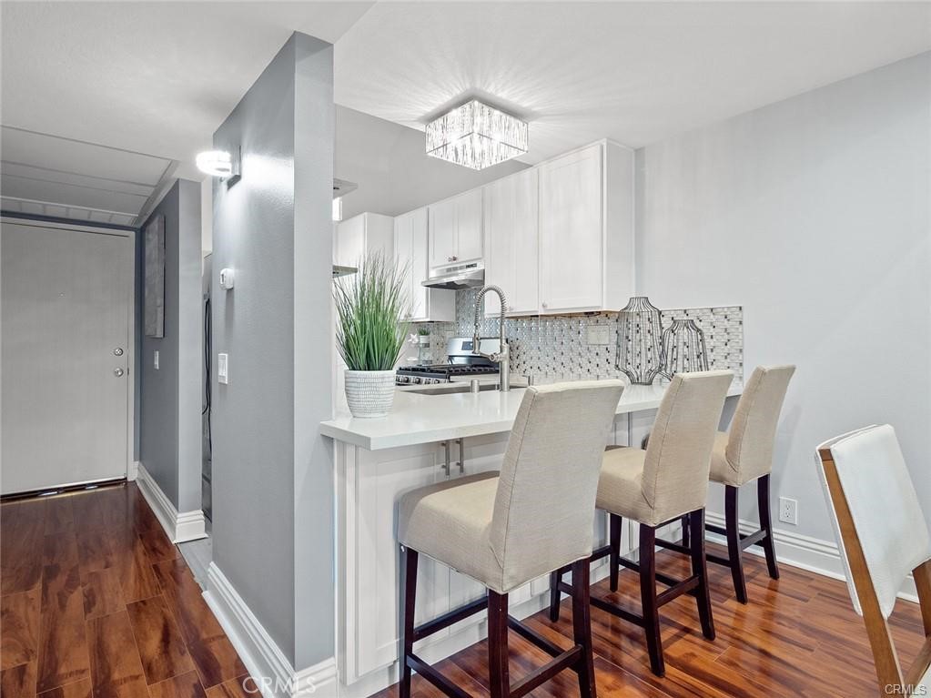 61 Orange Blossom Irvine, CA 92618 - Photo 7 of 40 a dining room with wooden floor a chandelier a wooden table and chairs