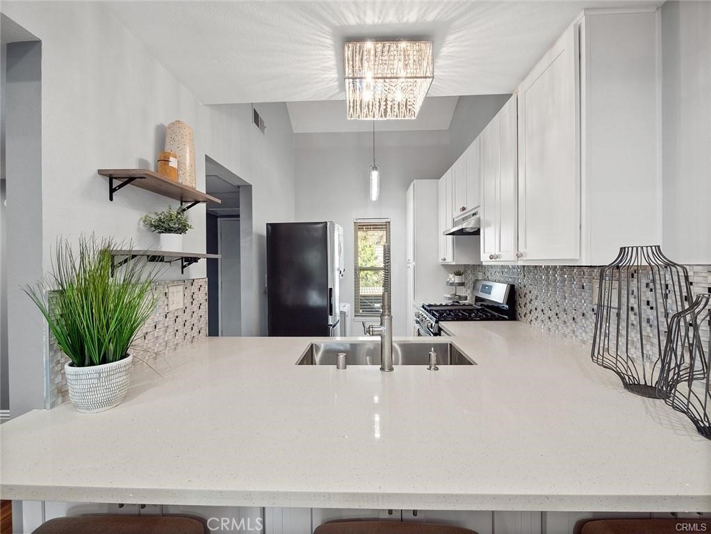 61 Orange Blossom Irvine, CA 92618 - Photo 8 of 40 a kitchen with a refrigerator a sink and a potted plant