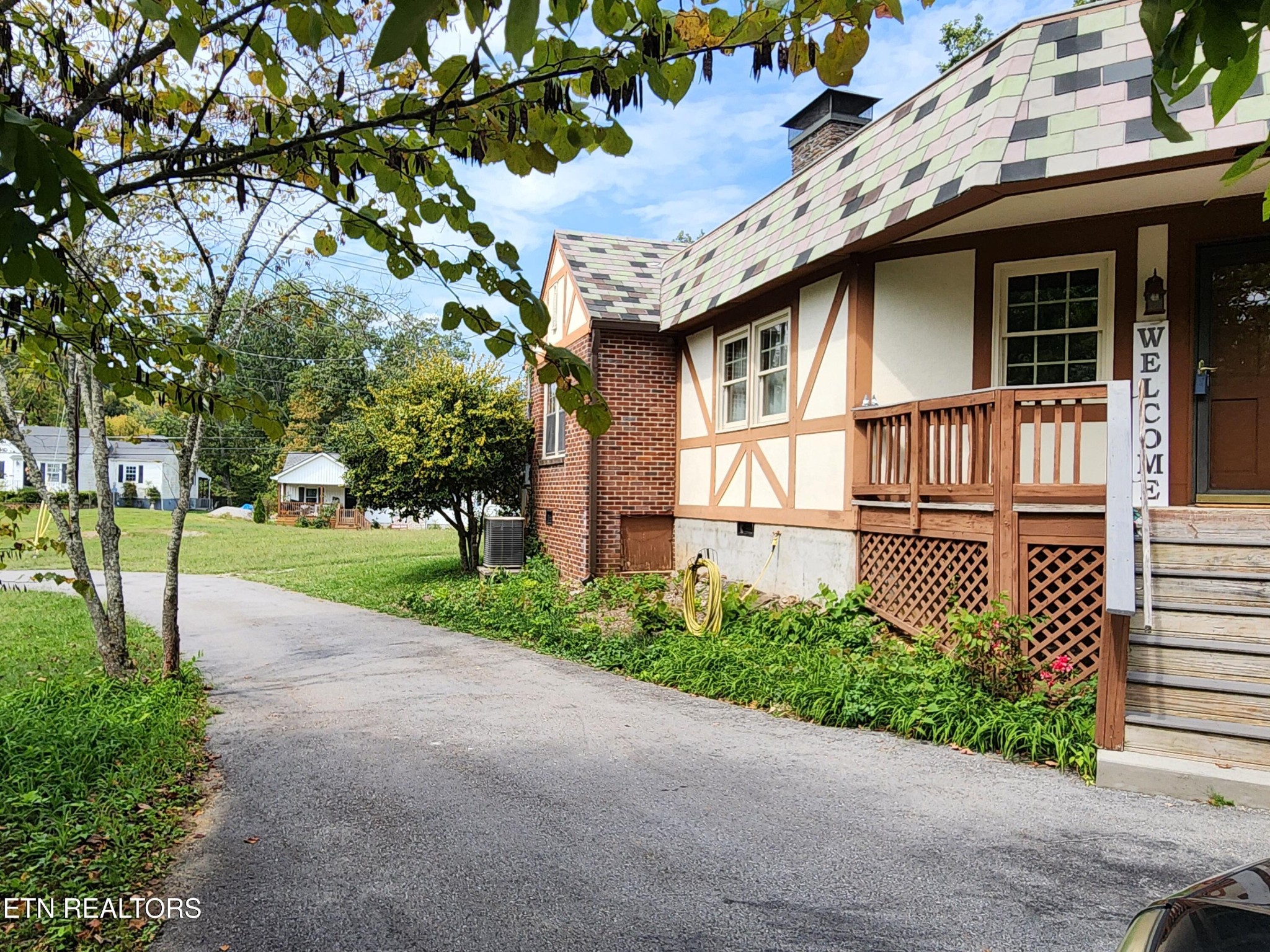 200 East Red Bud Road Knoxville, TN 37920 - Photo 3 of 60 a brick house with a small yard plants and large trees
