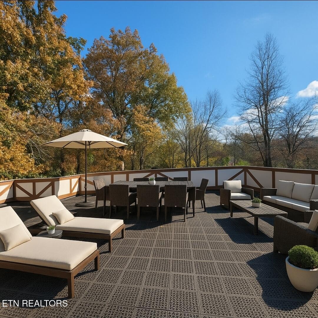 200 East Red Bud Road Knoxville, TN 37920 - Photo 34 of 60 a view of a patio with couches table and chairs under an umbrella with large trees