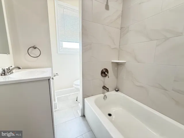 a bathroom with a tub a sink and a large mirror