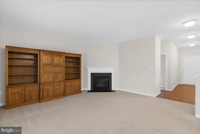 a view of an empty room with a fireplace and cabinet