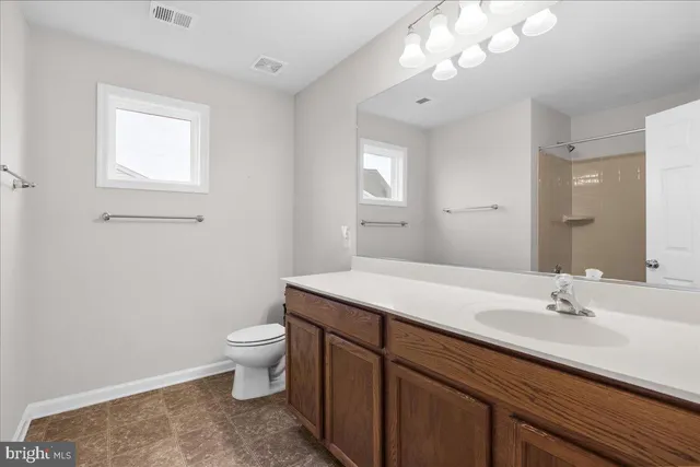 a bathroom with a sink a toilet and a mirror