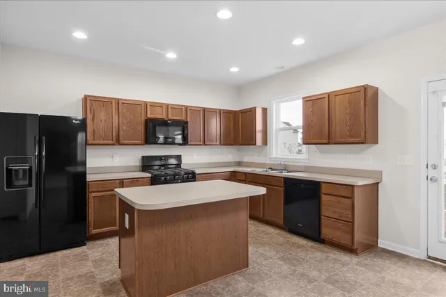 a kitchen with stainless steel appliances granite countertop a refrigerator stove a sink and a microwave