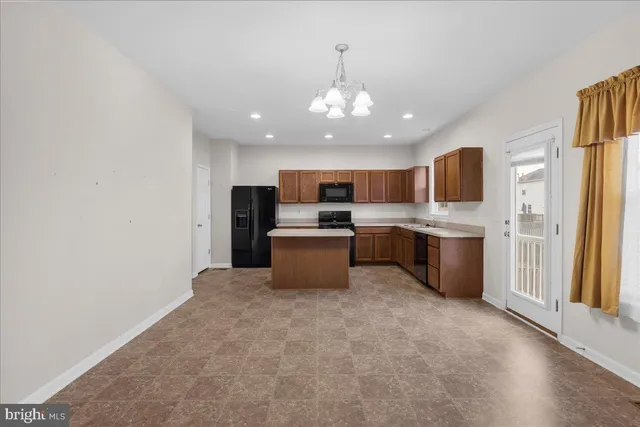 a kitchen with stainless steel appliances granite countertop a refrigerator oven a sink dishwasher with a dining table and chairs