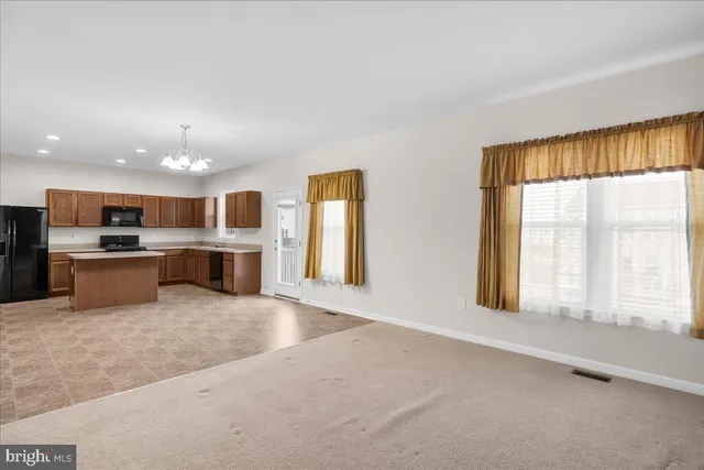 a large kitchen with stainless steel appliances granite countertop a stove and a large window