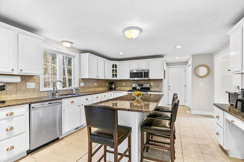 69 Paradise Lane Rochester, MA 02770 - Photo 9 of 38 a kitchen with a table chairs microwave and cabinets