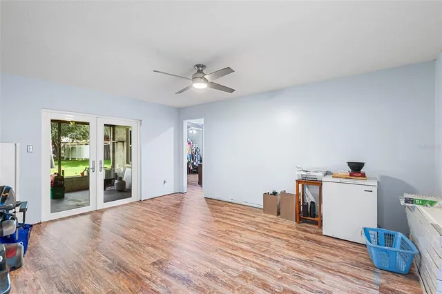 a view of a livingroom with wooden floor and a ceiling fan