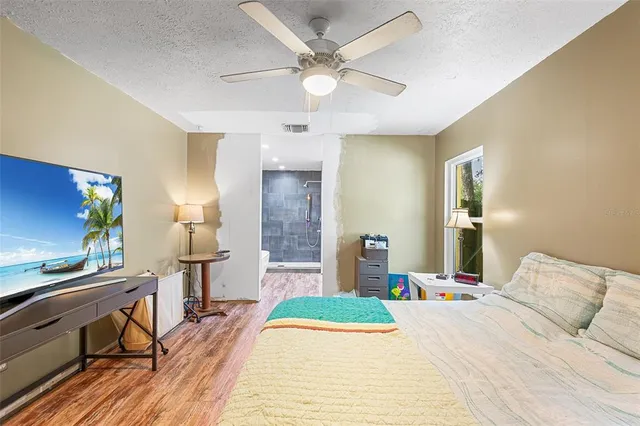 a bedroom with a bed and a flat screen tv