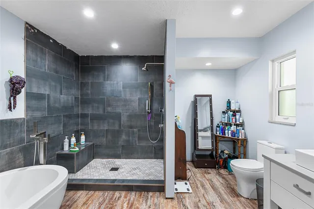 a bathroom with a sink a toilet and shower