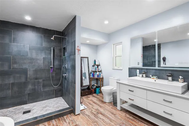 a bathroom with a mirror shower sink and toilet