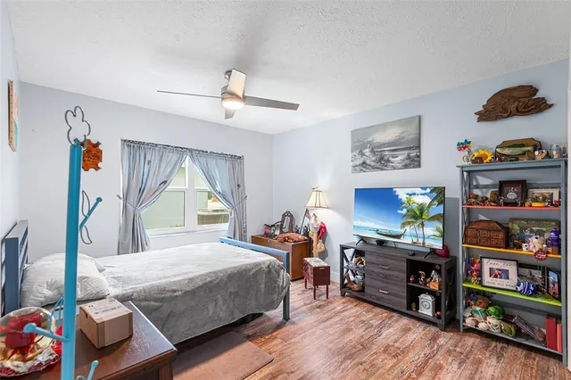 a bedroom with furniture a bed and a wooden floor