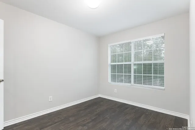 a view of an empty room with wooden floor