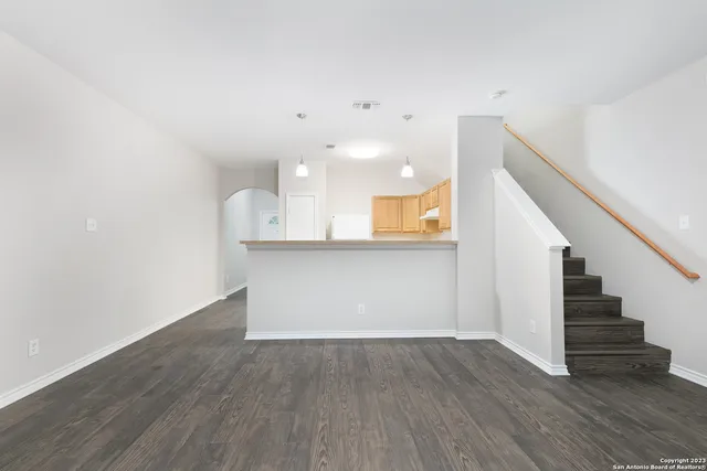 a view of a kitchen with wooden floor and stairs