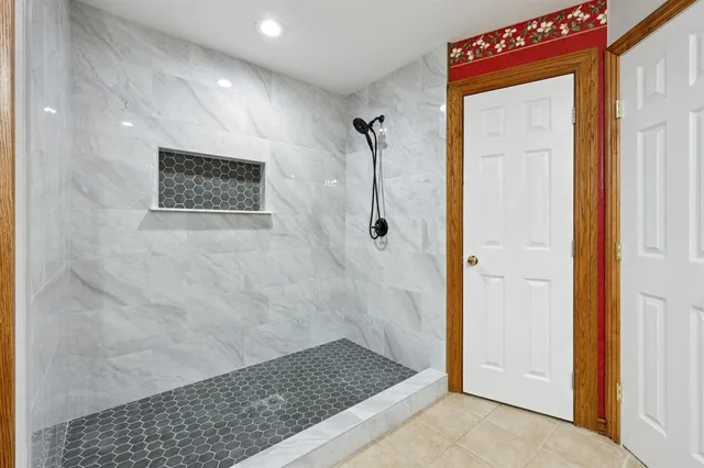 a spacious bedroom with a bed and a television