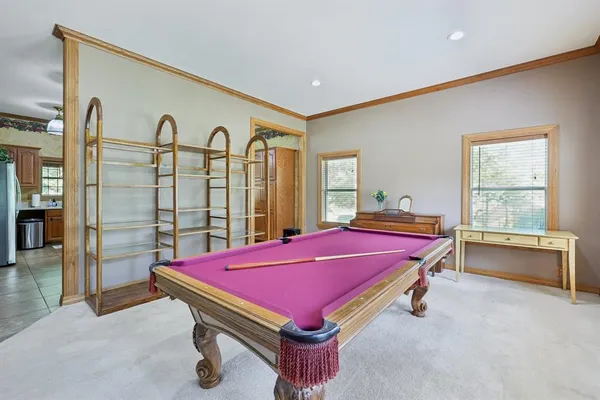a room with pool table and windows