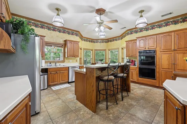 a large kitchen with a table chairs and refrigerator