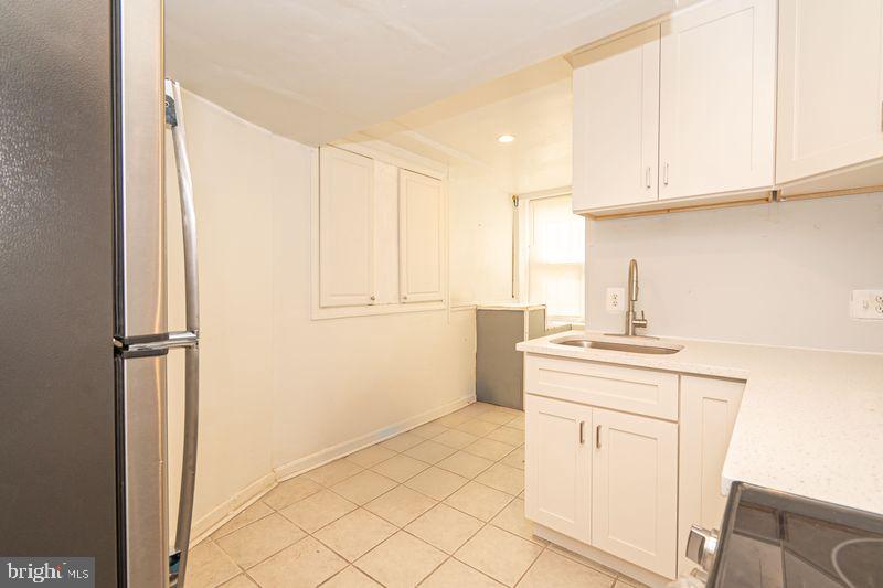 307 East 25th Street, Unit BASEMENT APARTMENT Baltimore, MD 21218 - Photo 17 of 21 a kitchen with a sink cabinets and appliances