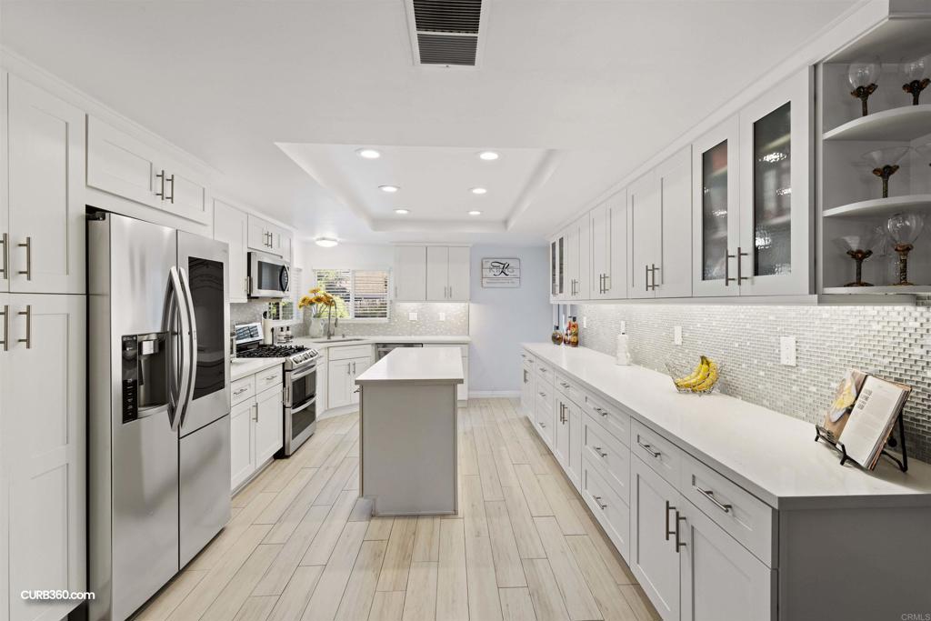 3155 Roadrunner Road San Marcos, CA 92078 - Photo 1 of 1 a kitchen with white cabinets and stainless steel appliances
