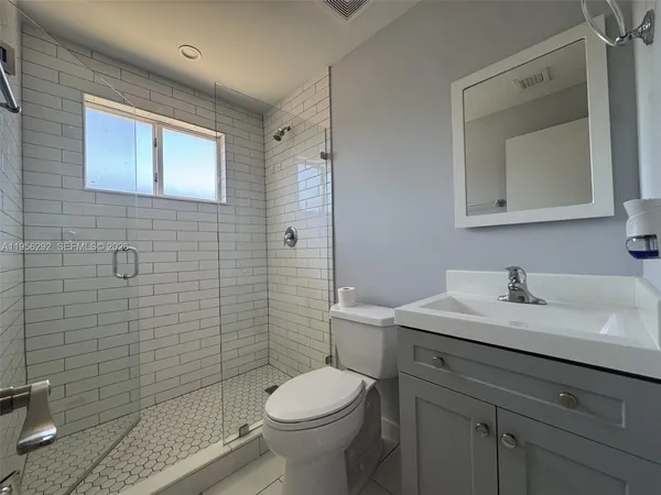 a bathroom with a toilet sink vanity and mirror