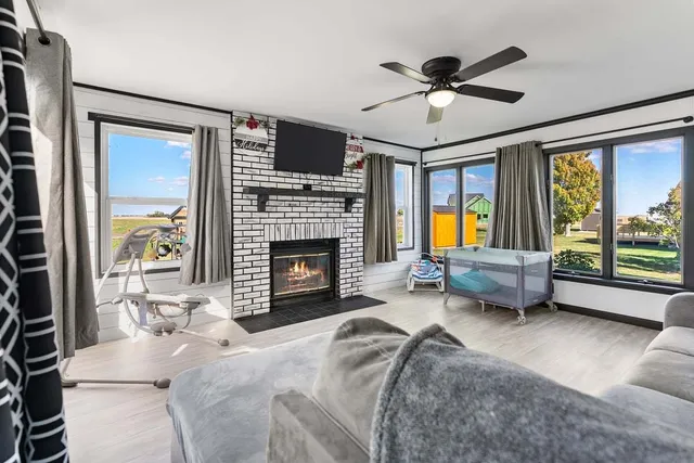 a living room with furniture fireplace and a large window
