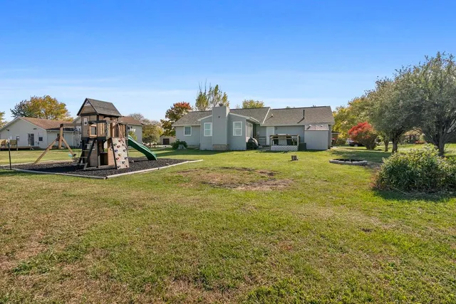 a view of a large house with a big yard and large trees