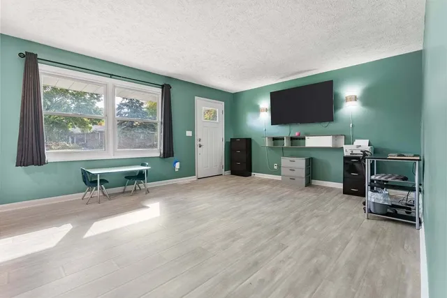 a living room with furniture a flat screen tv and a large window