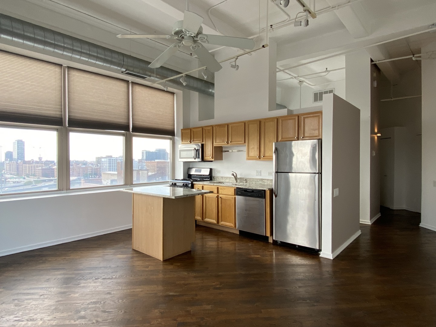500 South Clinton Street, Unit 1017 Chicago, IL 60607 - Photo 5 of 12 a kitchen with a refrigerator a stove top oven a sink and a large window