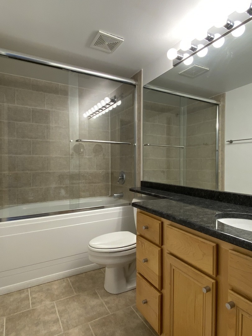 500 South Clinton Street, Unit 1017 Chicago, IL 60607 - Photo 10 of 12 a bathroom with a granite countertop sink a toilet and bathtub