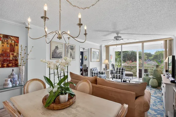 a dining room with furniture a potted plant and a chandelier