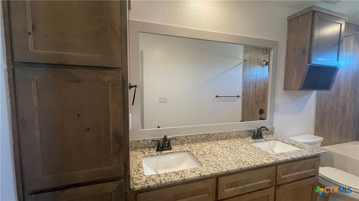 2408 Duntov Drive Temple, TX 76504 - Photo 21 of 41 a bathroom with a granite countertop sink and a mirror