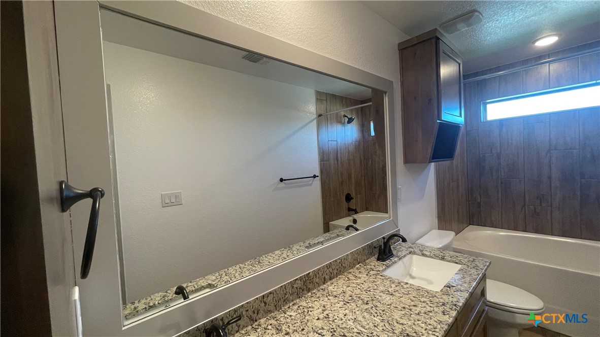 2408 Duntov Drive Temple, TX 76504 - Photo 24 of 41 a bathroom with a granite countertop sink and a mirror