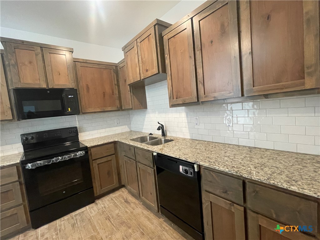 2408 Duntov Drive Temple, TX 76504 - Photo 7 of 41 a kitchen with stainless steel appliances granite countertop a sink stove and microwave