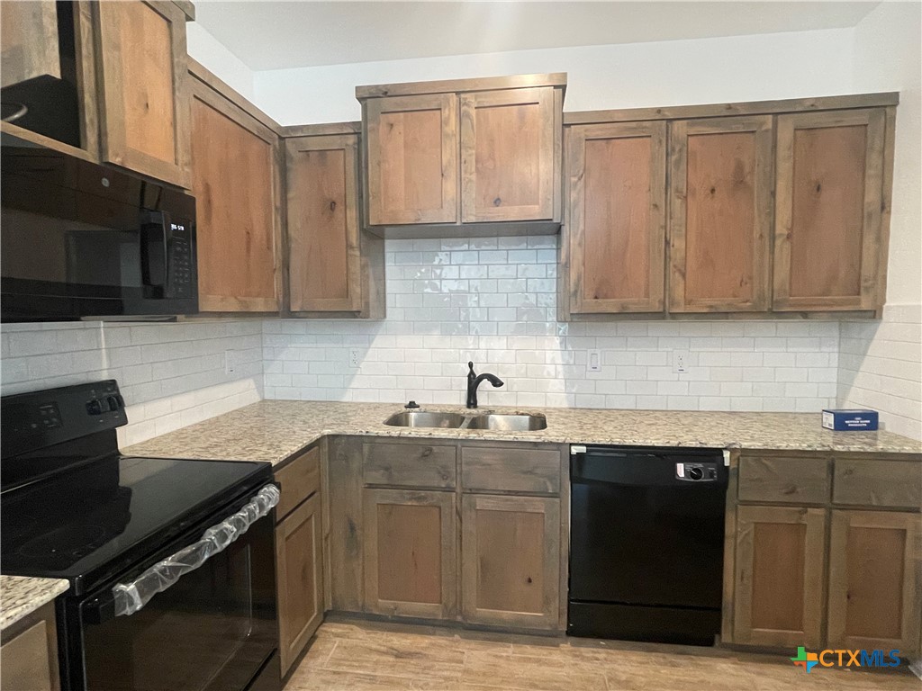 2408 Duntov Drive Temple, TX 76504 - Photo 8 of 41 a kitchen with stainless steel appliances granite countertop a sink stove and cabinets